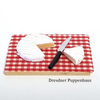 Camembert-Käse mit Messer auf Brett