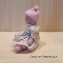 Baby mit Blumenkleid und Mütze